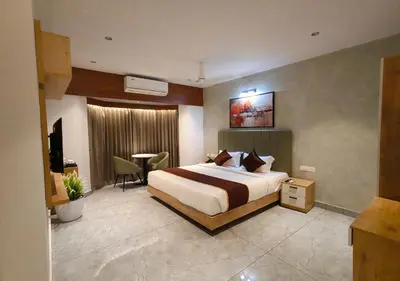a hotel room with a bed and a desk at Mayo Suites in Palakkad