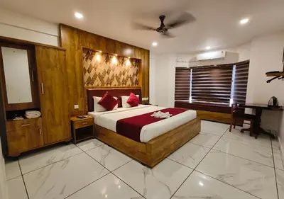 a bedroom with a large bed and a desk in it at Mayo Suites in Palakkad