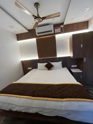a bedroom with a large bed with a ceiling fan at The Tendoinn in Pollāchi