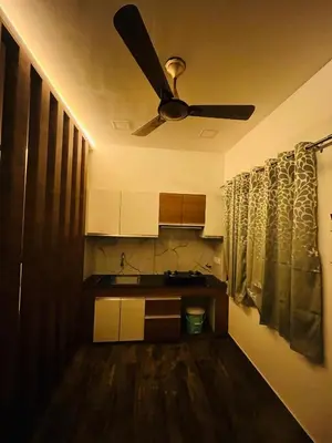 a kitchen with a ceiling fan in a room at The Tendoinn in Pollāchi