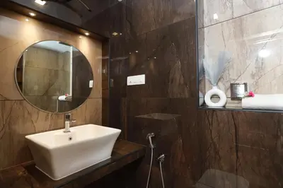 a bathroom with a sink and a mirror at Liwa Tower Hotel & Business Center in Kunnamkulam