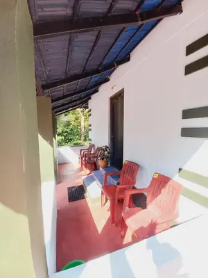 a living room with chairs and a table at Nature Greens Cottage in Madikeri