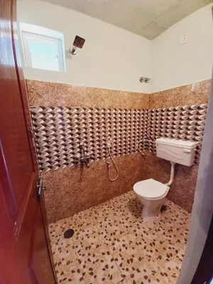 a bathroom with a toilet and a shower at Nature Greens Cottage in Madikeri