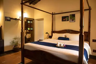 a bedroom with a large bed with a wooden frame at Akshaya Bungalow by Sparsa in Sethumadai