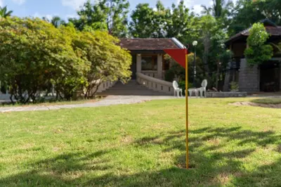 a red flag in the grass in front of a house at Akshaya Bungalow by Sparsa in Sethumadai