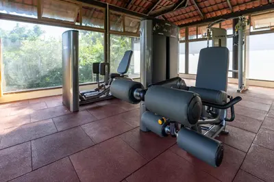 a gym with cardio equipment in a room with windows at Akshaya Bungalow by Sparsa in Sethumadai