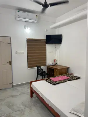 a bedroom with a bed and a desk and a table at New star homes in Kotamangalam