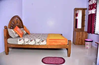 a bedroom with a bed with a wooden frame and a rug at Madhuvana Homestay Coorg in Madikeri