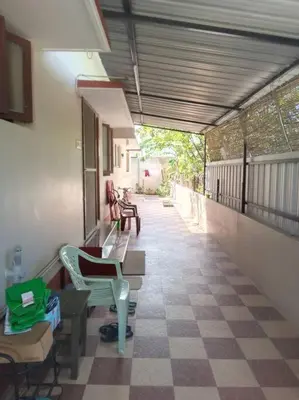 a porch with chairs and tables on a balcony at Aathira's 2 Bedroom house @ Heart of Coimbatore in Coimbatore