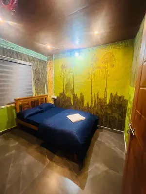 a bedroom with a bed with a painting on the wall at Elora Resort Wayanad in Kalpetta