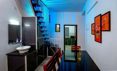 a bathroom with blue walls and a staircase with a sink at The Vogue - Luxury Private Pool Villa , Athirappilly in Athirappilly