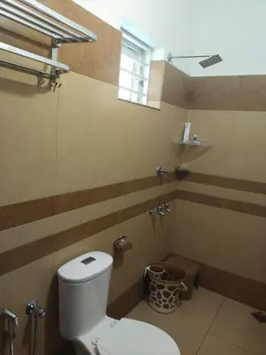 a bathroom with a white toilet in a room at The Vogue - Luxury Private Pool Villa , Athirappilly in Athirappilly