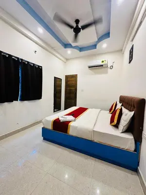 a bedroom with a bed with a ceiling fan at ROSEPARK INN in Mysore