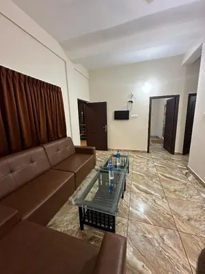 a living room with a couch and a table at ZAHIR RESIDENCY in Kondotti