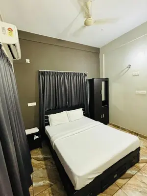 a bedroom with a large bed with a black headboard at ZAHIR RESIDENCY in Kondotti