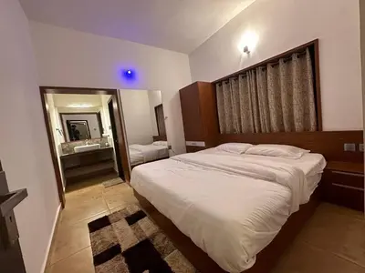 a bedroom with a large bed and a mirror at Vue D'en Haut, Ooty,India in Ooty