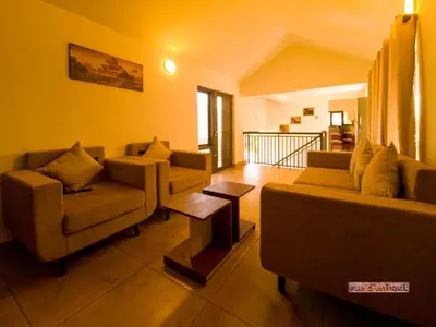 a living room with two couches and a table at Vue D'en Haut, Ooty,India in Ooty