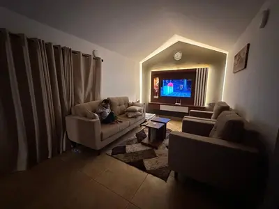 a man sitting on a couch in a living room at Vue D'en Haut, Ooty,India in Ooty