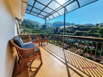 a balcony with chairs and a view of the mountains at Vue D'en Haut, Ooty,India in Ooty