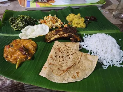a green plate of food on a banana leaf at Spice Garden Farm house in Sultan Bathery