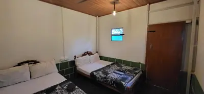 a small room with a bed and a door at SPM Residency, From Live2Travel Group. in Masinagudi