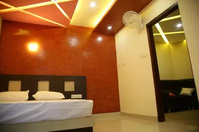 a bedroom with a bed and a red wall at City Tower Lodge in Nilambūr