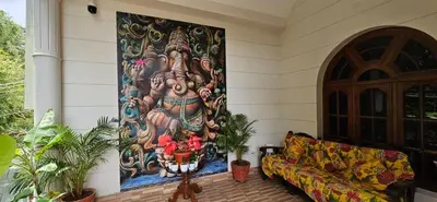 a large painting on the wall of a house with a couch at RAATREE in Mysore