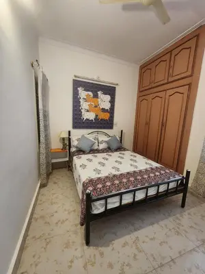 a bedroom with a bed and a large wooden door at RAATREE in Mysore