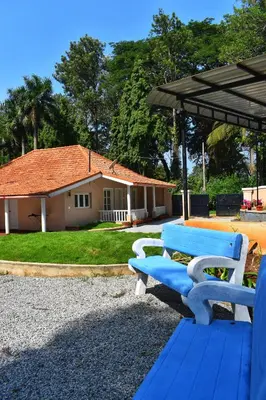 a blue bench sitting in front of a house at Rochas Valley Homestay in Suntikoppa