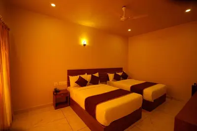 two beds in a bedroom with orange walls at KOTTACKAL NATURE INN in Nedumbassery