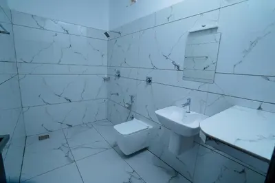 a white bathroom with a sink and a toilet at KOTTACKAL NATURE INN in Nedumbassery