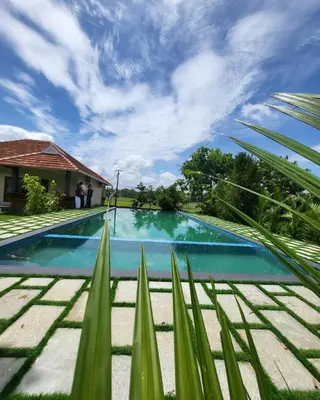 a swimming pool in front of a house at KOTTACKAL NATURE INN in Nedumbassery