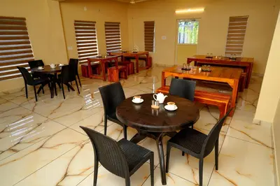 a restaurant with tables and chairs in a room at KOTTACKAL NATURE INN in Nedumbassery