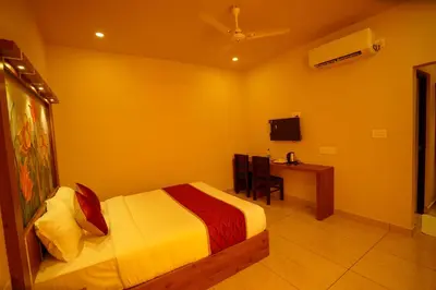 a bedroom with a bed and a desk and a television at KOTTACKAL NATURE INN in Nedumbassery