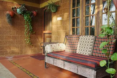 a porch with a bench and a window at Sukrutham Farmstay in Trichūr