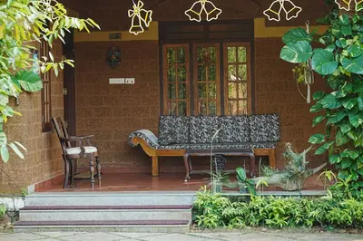 a bench sitting on the porch of a house at Sukrutham Farmstay in Trichūr