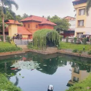 a pool of water in front of a house at Kottaram Hotels Ottaplam in Palakkad