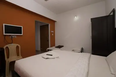 a bedroom with a bed and a tv on the wall at KV Residency in Coimbatore