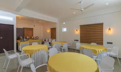 a conference room with yellow tables and white chairs at Treebo Amigos Residency in Cochin