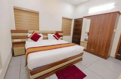 a bedroom with a large bed with red pillows at Greenfield Homestay in Vythiri