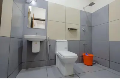 a bathroom with a sink and a toilet and a mirror at Greenfield Homestay in Vythiri