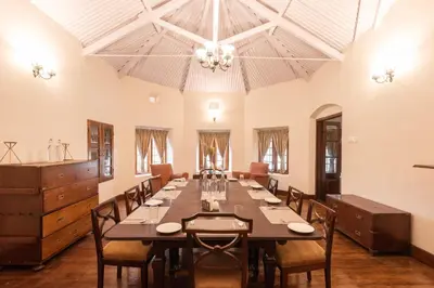 a large dining room with a long table and chairs at Ibex Resorts, Coonoor Leewood in Coonoor