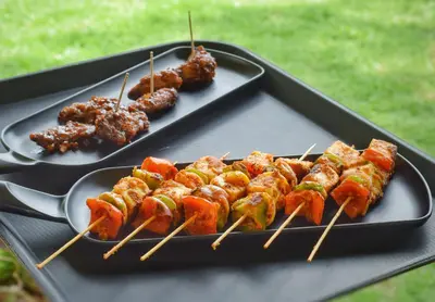 two plates of food on skewers on a table at Ibex Resorts, Coonoor Leewood in Coonoor