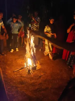 a group of people standing around a fire at CELESTIAL HOMESTAY in Pinangode