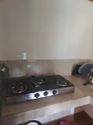 a stove top oven in a kitchen at CELESTIAL HOMESTAY in Pinangode