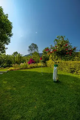 a green yard with a flag in the grass at amã Stays & Trails Raven's Nest , Kotagiri in Kotagiri