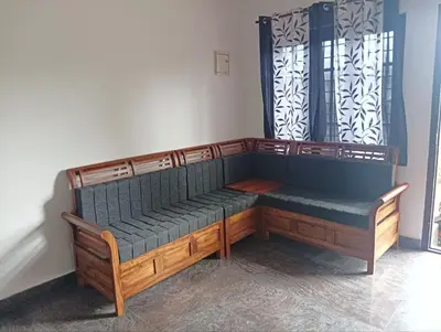 a wooden bench sitting in the corner of a room at BHASURI SERVICED VILLA in Varagampadi