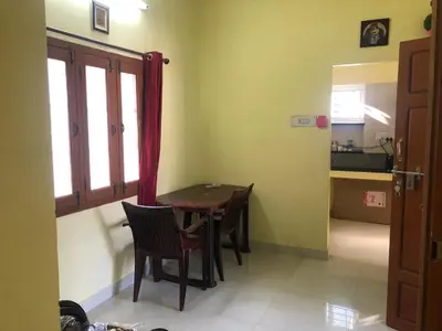 a dining room with a table and chairs in a room at A Sweet home Homestay Second Floor in Palani
