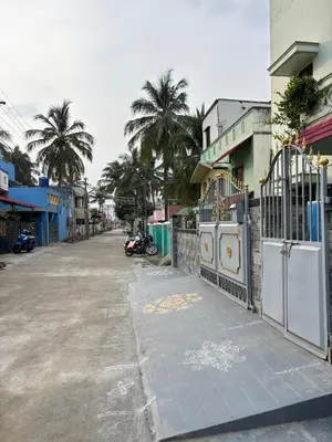 an empty street with palm trees and a fence at A Sweet home Homestay Second Floor in Palani