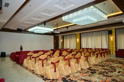 a room with a bunch of chairs in it at Hotel Golden Riviera in Mysore